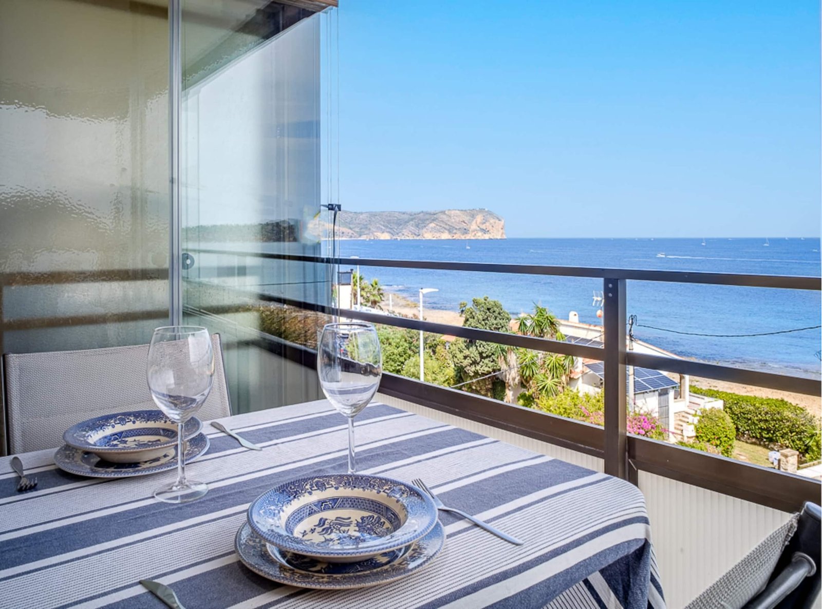 Terraza con mesa puesta y vistas al mar en un apartamento turístico de Jávea gestionado por Opal Properties