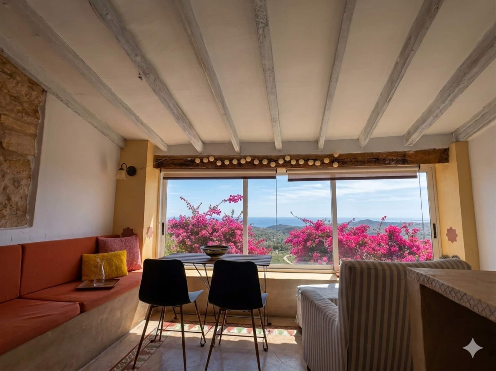 Salón con buganvillas en el ventanal de una casa turística en Aigües (Alicante) gestionada por Opal Properties